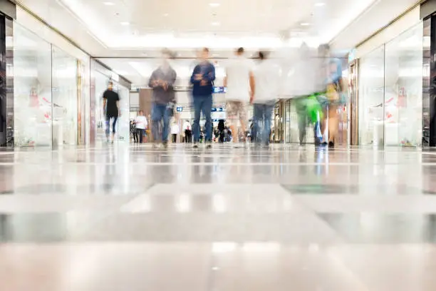 Motion blurred customers walking in shopping mall, Hong Kong