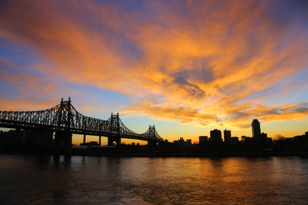 The morning sky comes alive with colors over the Queensboro Bridge spanning the East River in New York City.