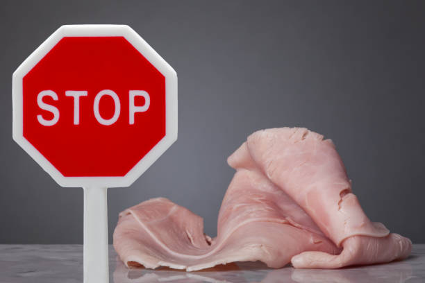 Do not eat meat A piece of boiled ham laying on a marble plate. In front a stop sign dont eat meat stock pictures, royalty-free photos & images