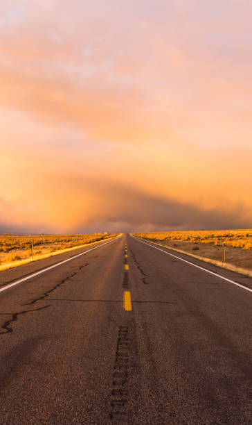 istock Storm Brews over Two Lane Highway At Sunset 690606920