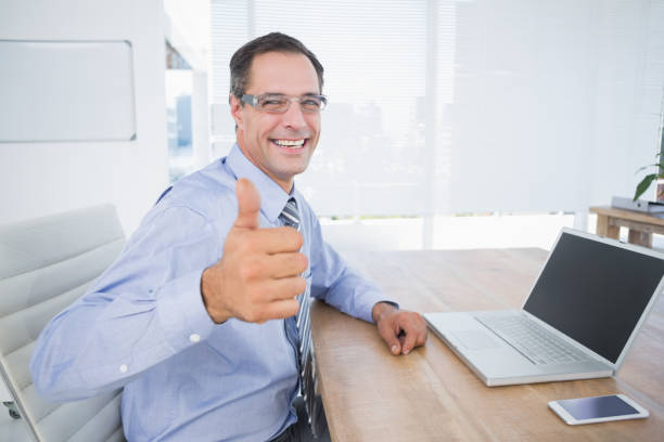 istock Businessman smiling at camera with thumbs up 690610484