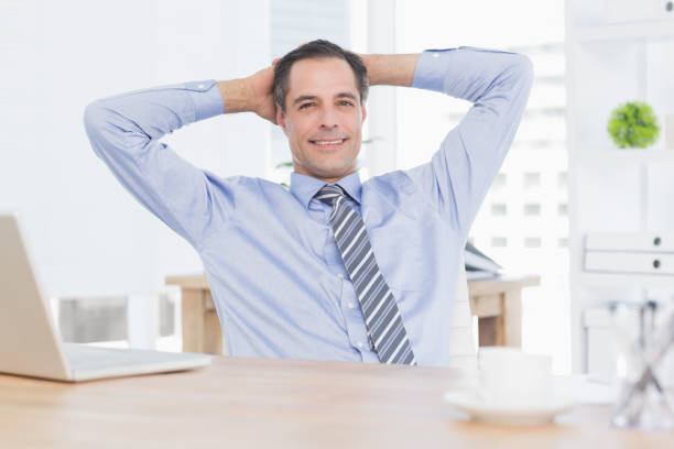 istock Smiling businessman relaxing on his office 690610706