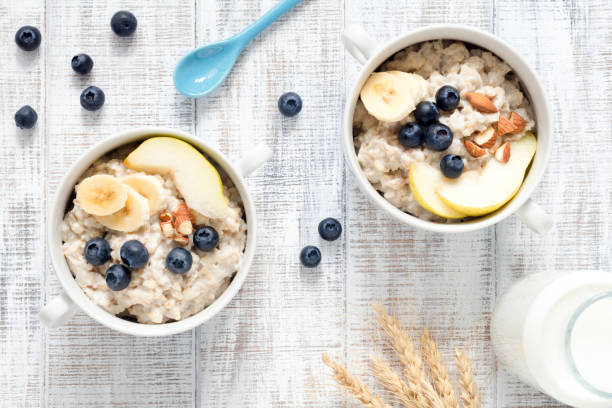 istock Oatmeal porridge in bowl on white table top view 690613616