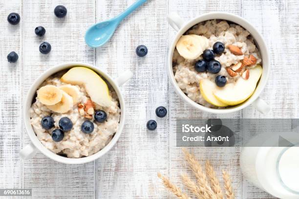 Oatmeal Porridge In Bowl On White Table Top View Stock Photo - Download Image Now - Rolled Oats, Berry, Blueberry