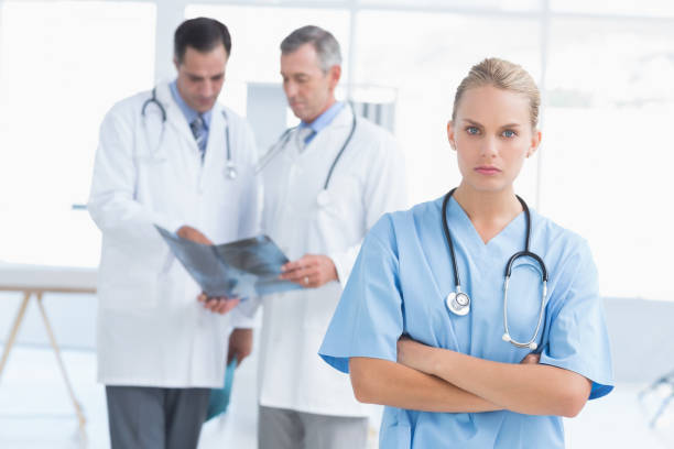 istock Irritated doctor looking at camera while her colleagues works 690639064