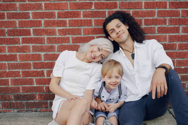 beautiful young family dad mom and a little boy with blond hair walking around the city and enjoying the sunshine, multi family black and white three way kiss stock pictures, royalty-free photos & images
