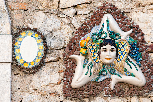 A typical ceramic Trinacria, the symbol of Sicily, hung along the streets of Taormina