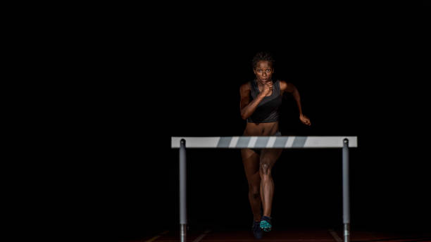 istock Female athlete running towards a hurdle 690648738