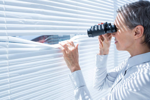 istock Businesswoman looking through binoculars in the office 690653808