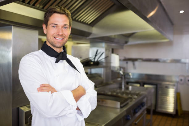 istock Smiling male cook with arms crossed in kitchen 690657548