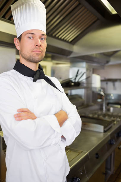 istock Serious male cook with arms crossed in kitchen 690657570