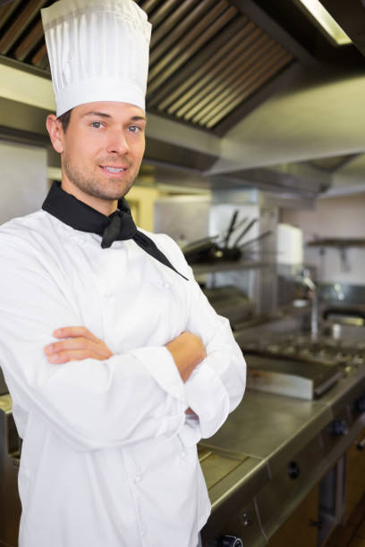 istock Smiling male cook with arms crossed in kitchen 690657588