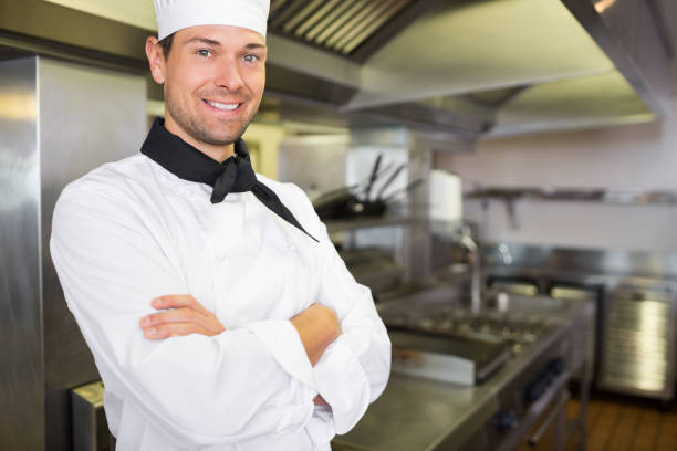 istock Smiling male cook with arms crossed in the kitchen 690657604