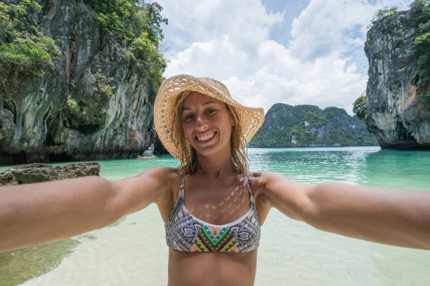 istock Young woman taking selfie on tropical beach 690664750