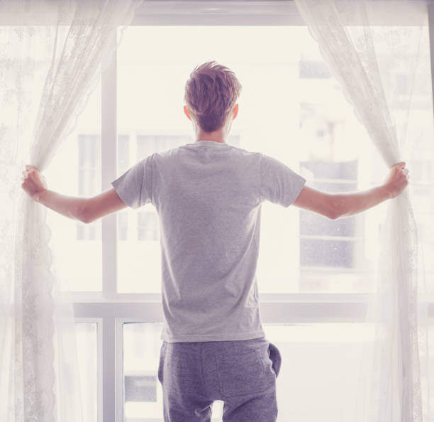 istock man and hope concept - man opening window curtains business concept. 690667502