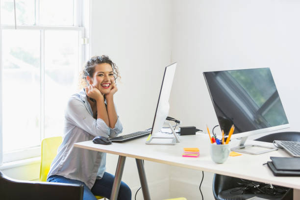 istock Young woman working in office, at computer 690672666