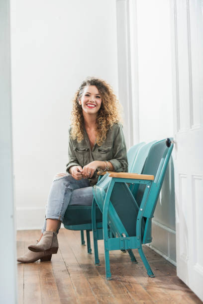 istock Young woman sitting in room smiling at camera 690672998