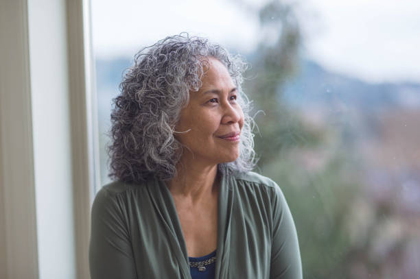 istock Woman sitting in window sill thinking 690675748