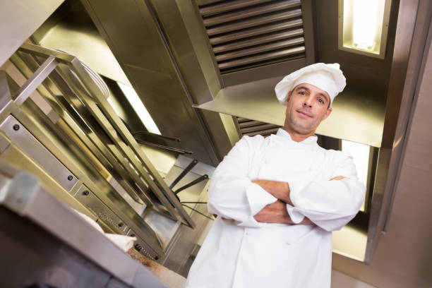 istock Smiling male cook with arms crossed in kitchen 690690260