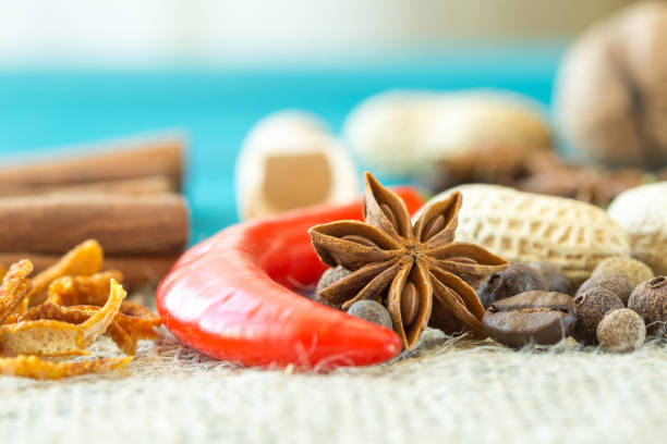 red chili pepper, coffee beans, Crude peanots, zest and star anise on wooden table. imitation seascape