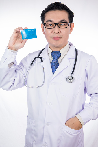 Asian Chinese male doctor holding credit card with stethoscope in isolated White Background