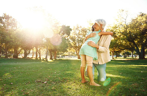 Shot of a little girl and her grandmother in a loving embrace at the park