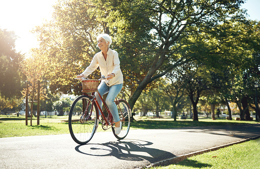 Shot of a senior woman enjoying a bike ride in the park