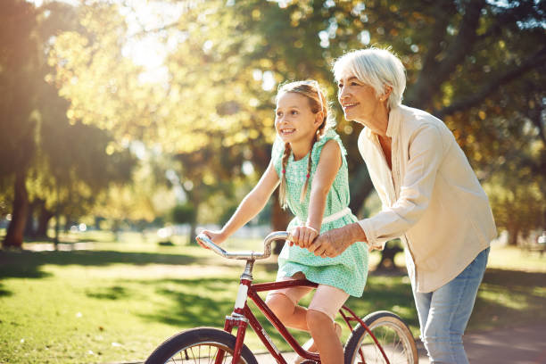 grandma has one rule - always have fun! - candid people casual bicycle imagens e fotografias de stock