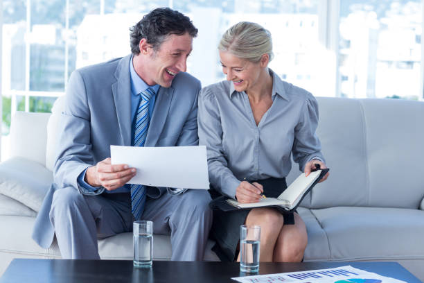 istock Smiling businessman and secretary looking at diary 690725070
