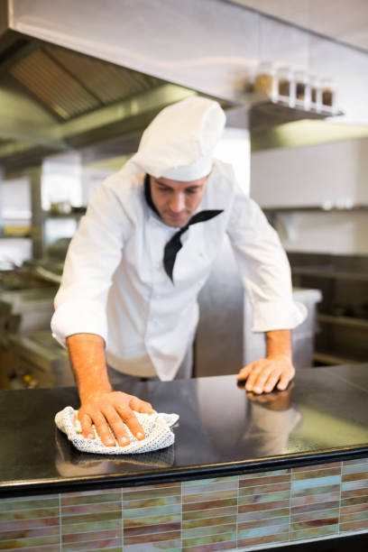 istock Male cook wiping kitchen counter 690727264