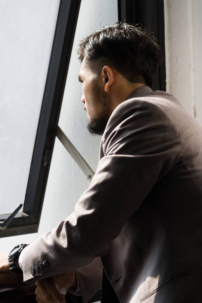 istock Stressed business man standing by the window. 690730410