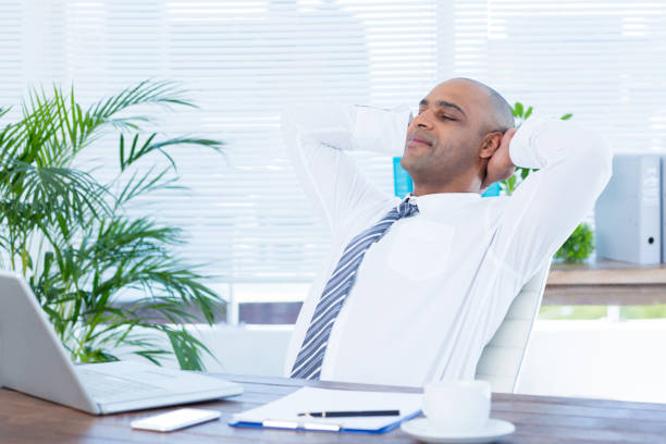 istock Relaxed businessman lying down in swivel chair 690730740