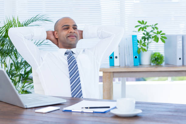 istock Relaxed businessman lying down in swivel chair 690730868