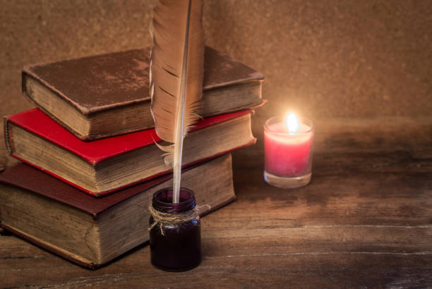 istock old books, scrolls, feather pen and inkwell on wooden table 690734392