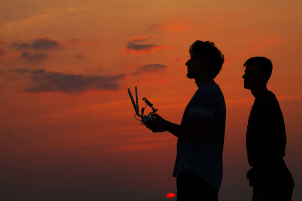 istock Silhouette of two man operating drone 690739702