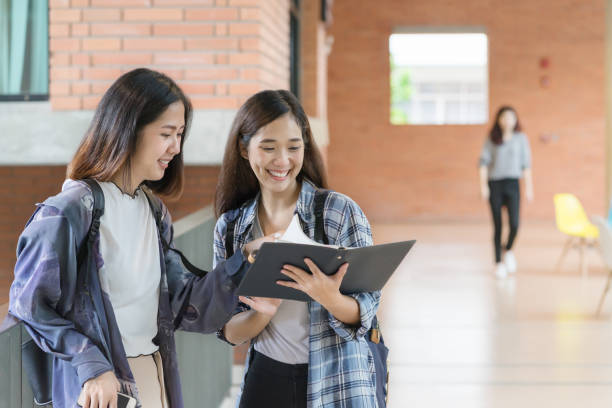 istock Two cute asian student talking at campus university. Education concept. 690742788