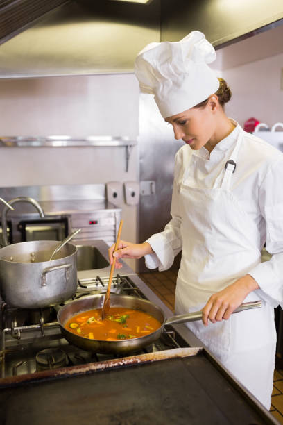 istock Concentrated female cook preparing food in kitchen 690758530