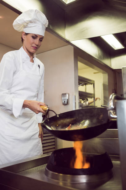 istock Female chef preparing food in kitchen 690758700