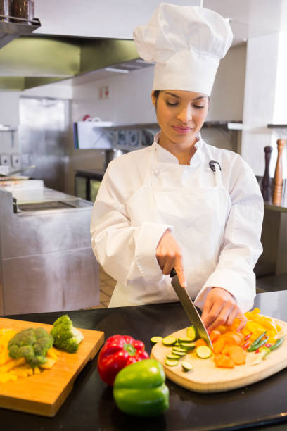 istock Female chef cutting vegetables in kitchen 690760848