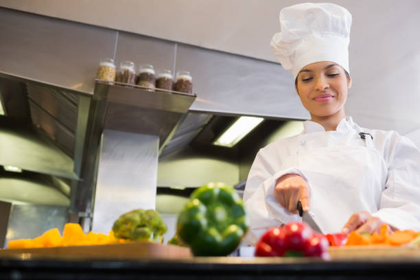 istock Female chef cutting vegetables in kitchen 690760936