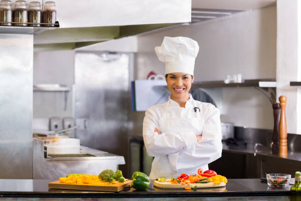 istock Smiling female chef with cut vegetables in kitchen 690761068