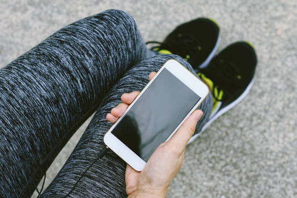 istock Jogger using smart phone, Female fitness exercise and cellphone concept. 690761570