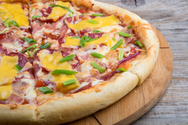 istock Whole pizza on a wooden tray 690775444