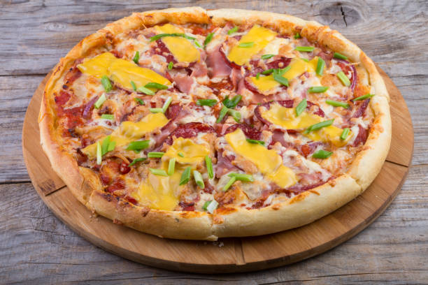 istock Whole pizza on a wooden tray 690775450