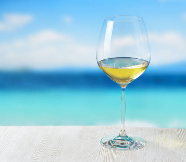 Glass of wine on beach background.