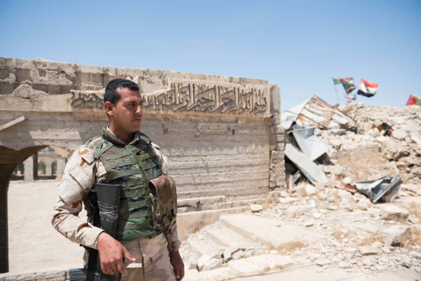 Ruins of Nabi Yunus shrine in Mosul, Iraq An Iraqi soldier stands guard at the ruins of the Nabi Yunus shrine in Mosul, Iraq. The so-called Islamic State blew up the shrine in 2014. islamic state stock pictures, royalty-free photos & images