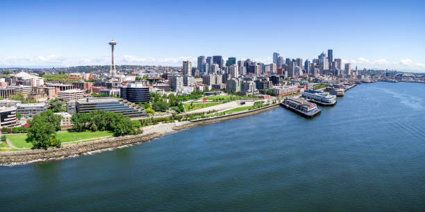Panoramic Helicopter View of Seattle, Washington Waterfront on Sunny Summer Day with Skyline of Buildings Aerial drone perspective with birds eye view on Elliot Bay with Puget Sound ocean water and city skyline of downtown skyscraper buildings in Pacific Northwest puget sound stock pictures, royalty-free photos & images
