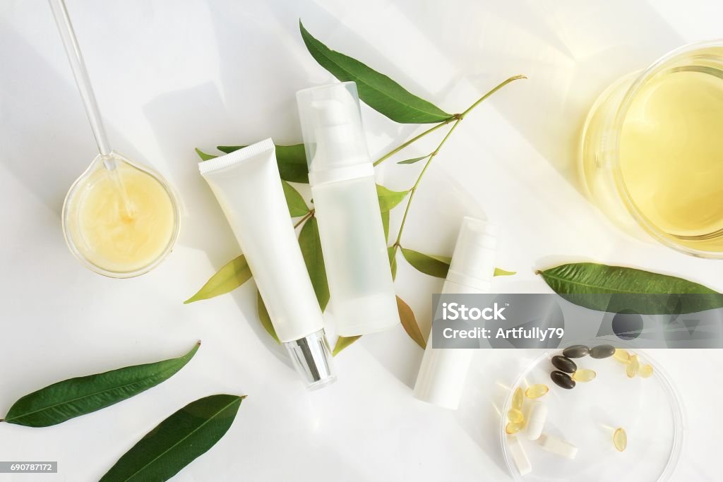 Cosmetic bottle containers with green herbal leaves, Blank label for branding mock-up, Natural beauty product concept. Skin Care Stock Photo