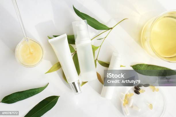 Cosmetic Bottle Containers With Green Herbal Leaves Blank Label For Branding Mockup Natural Beauty Product Concept Stock Photo - Download Image Now