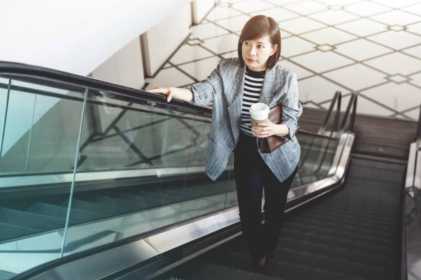 istock Working woman with coffee cup at Escalator 690787794